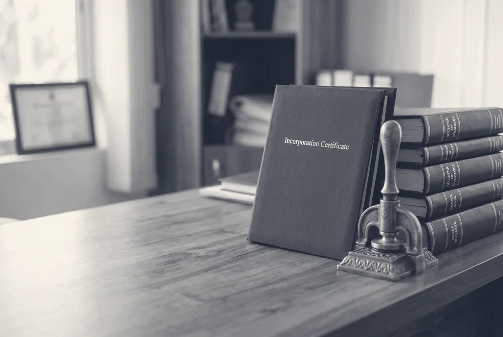 Company incorporation folder, common seal and statutory registers on an office desk